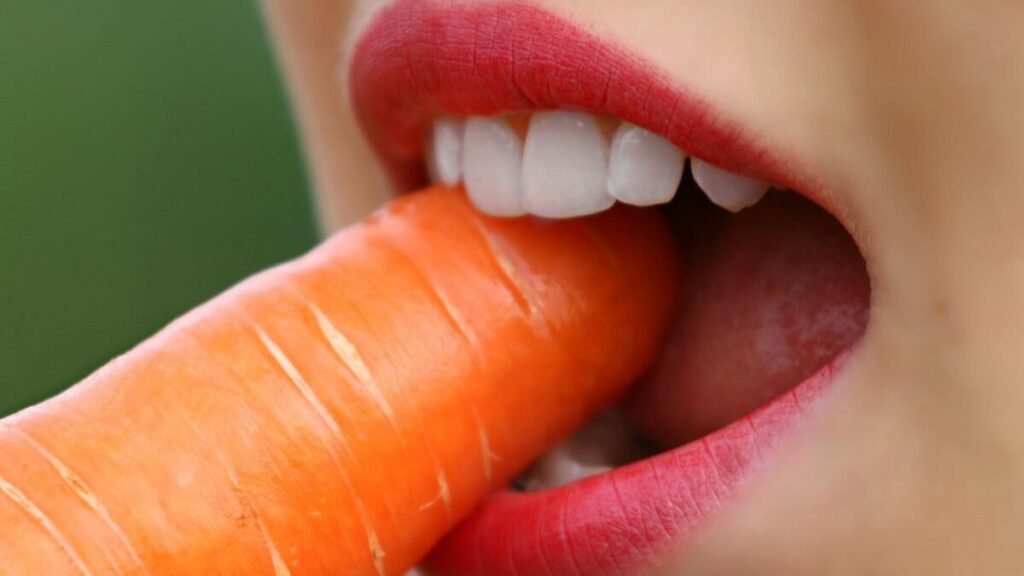 Mulher mordendo uma cenoura