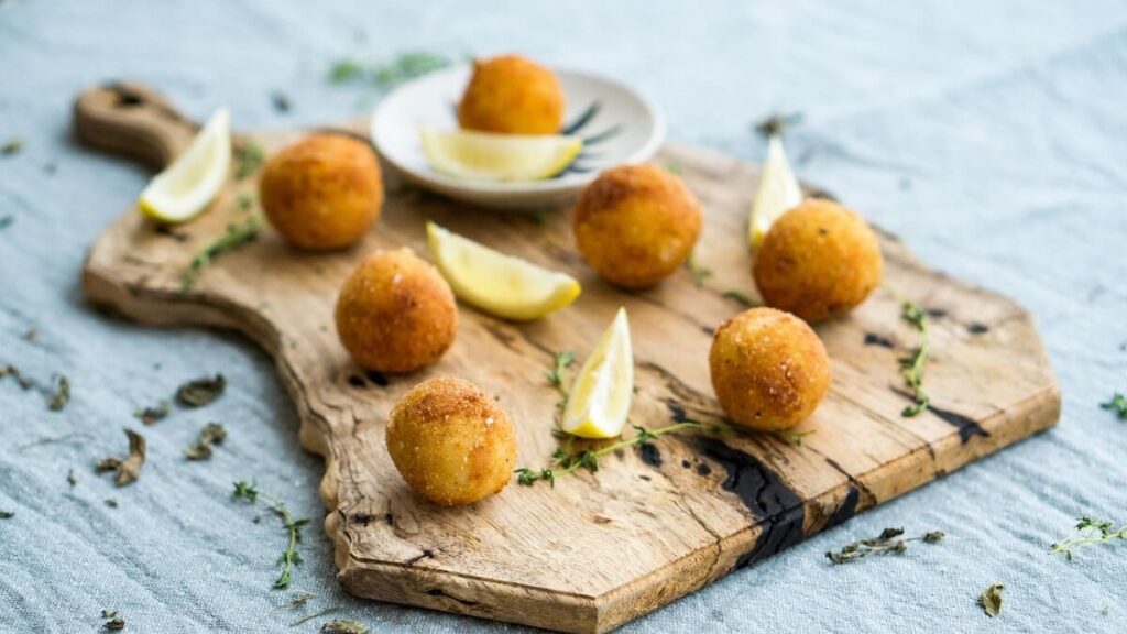 Como fazer bolinho de arroz com limão sobre tábua de madeira