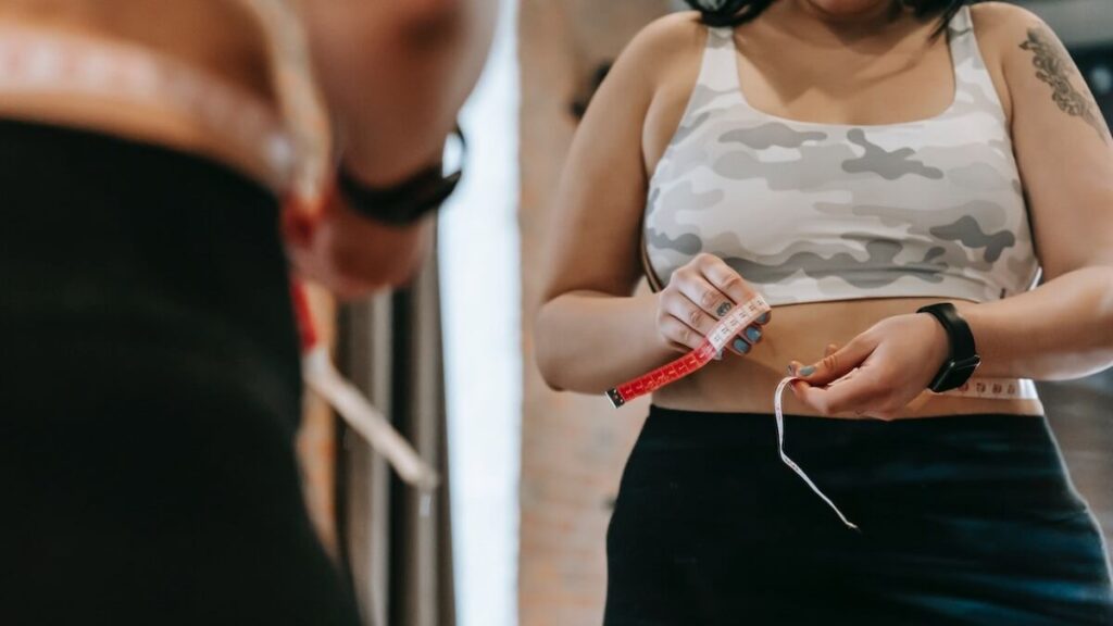 Mulher medindo cintura com uma fita