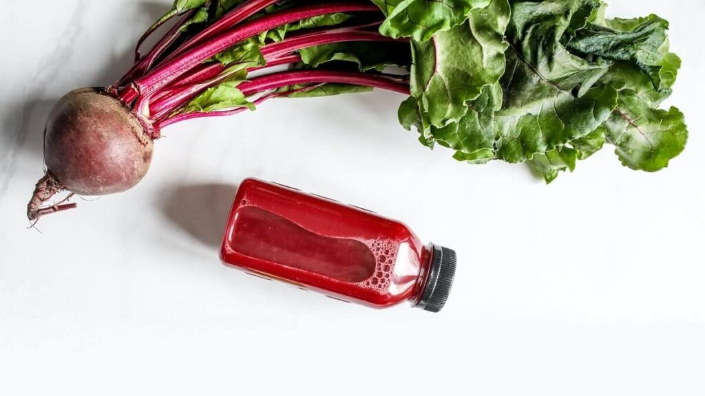 Pequena garrafa de plástico, com beterraba ao lado