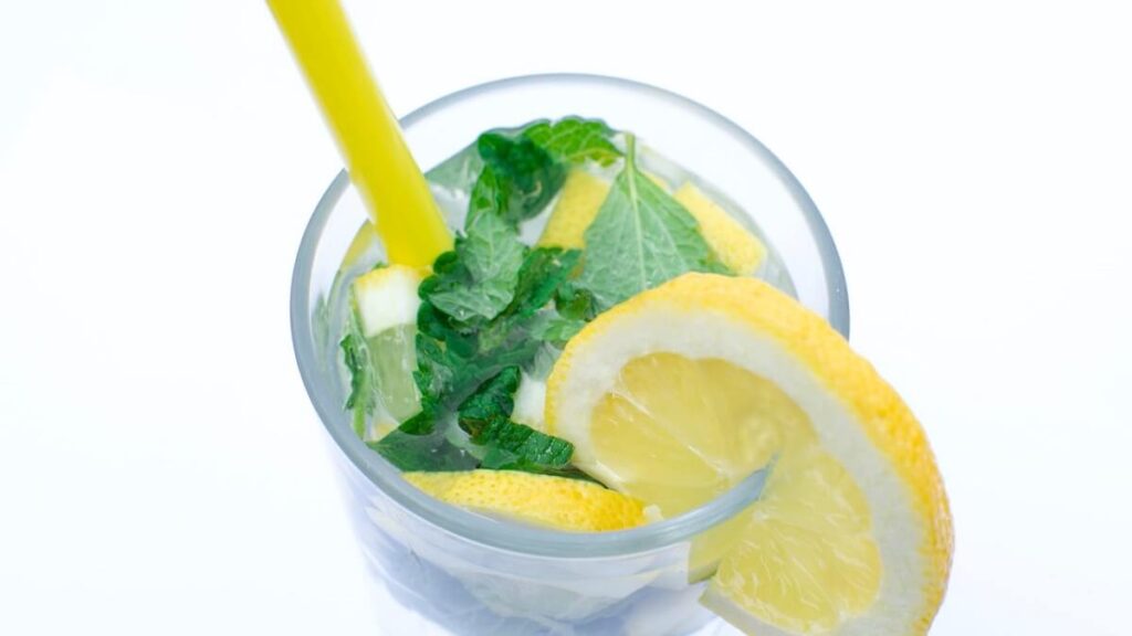 Copo com hortelã, gelo e limão amarelo