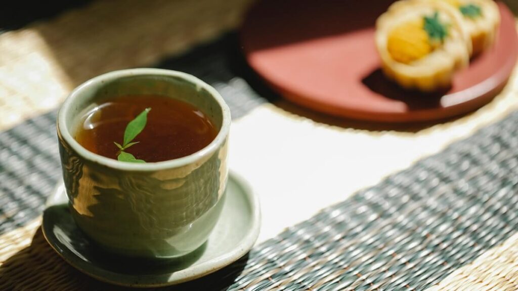 Xarope de hortelã em um xícara com bolachas ao fundo