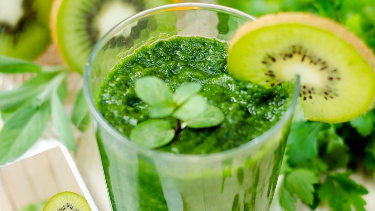 Xarope de menta em um copo com um kiwi decorando a borda