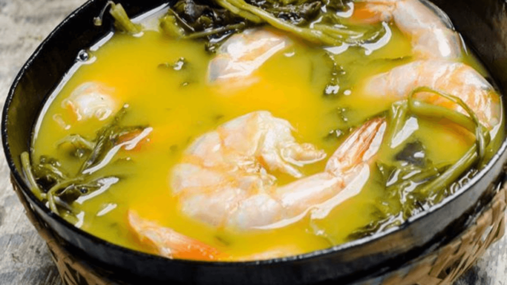tacaca aparenta ser uma sopa com folhas verdes, caldo amarelado e camarão